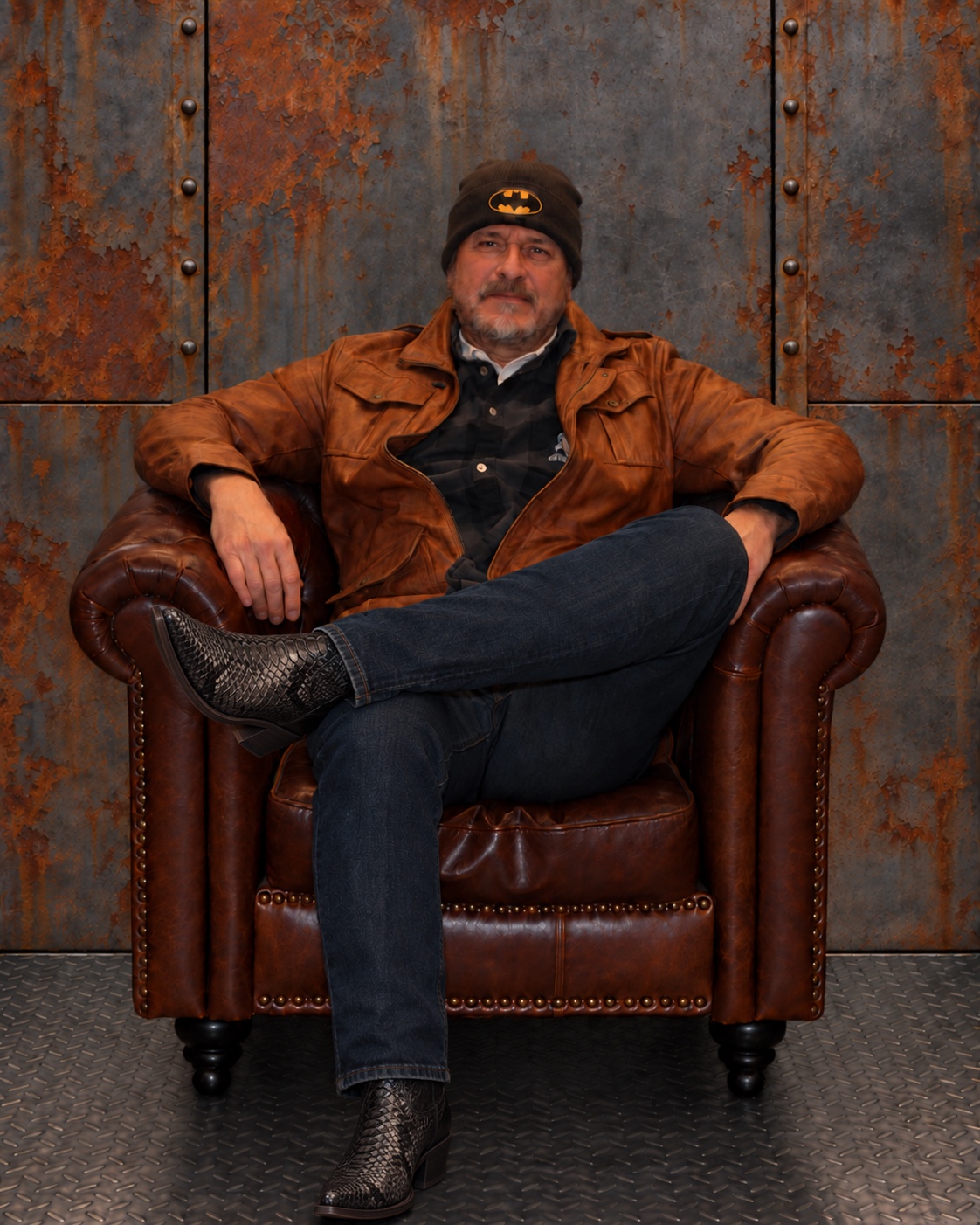 Fatpat Jones, guitars, seated in a leather armchair